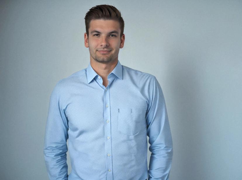 professional business photo of a handsome man wearing a light blue business shirt, standing against a solid light blue background